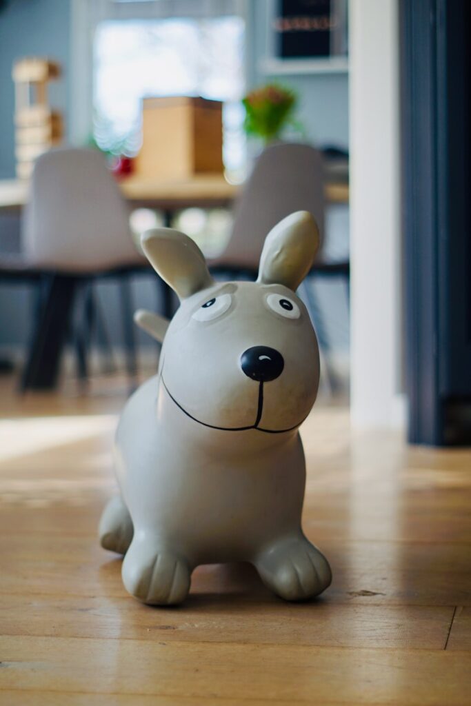 a ceramic dog figurine sitting on a wooden floor